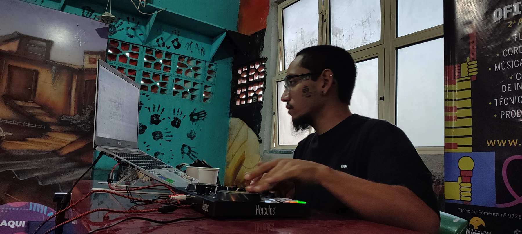 Participante utiliza controladora de DJ e computador em atividade de formação
