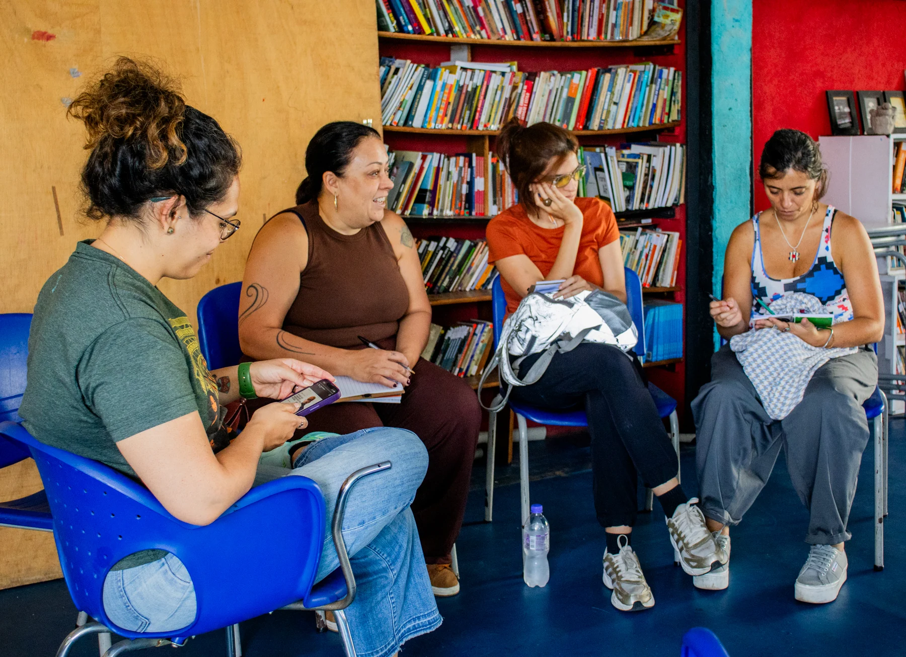 Visitantes sentadas registram anotações em cadernos